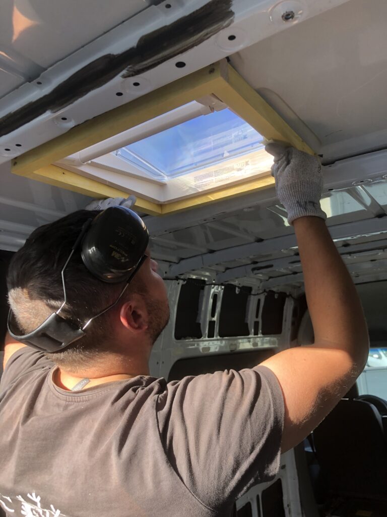 Photo de mon conjoint en train de poser le lanterneau sur notre mercedes sprinter aménagé