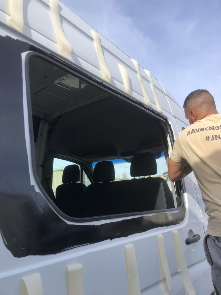 Photo montrant mon conjoint en train de poser la fenêtre sur la porte latérale de notre mercedes sprinter