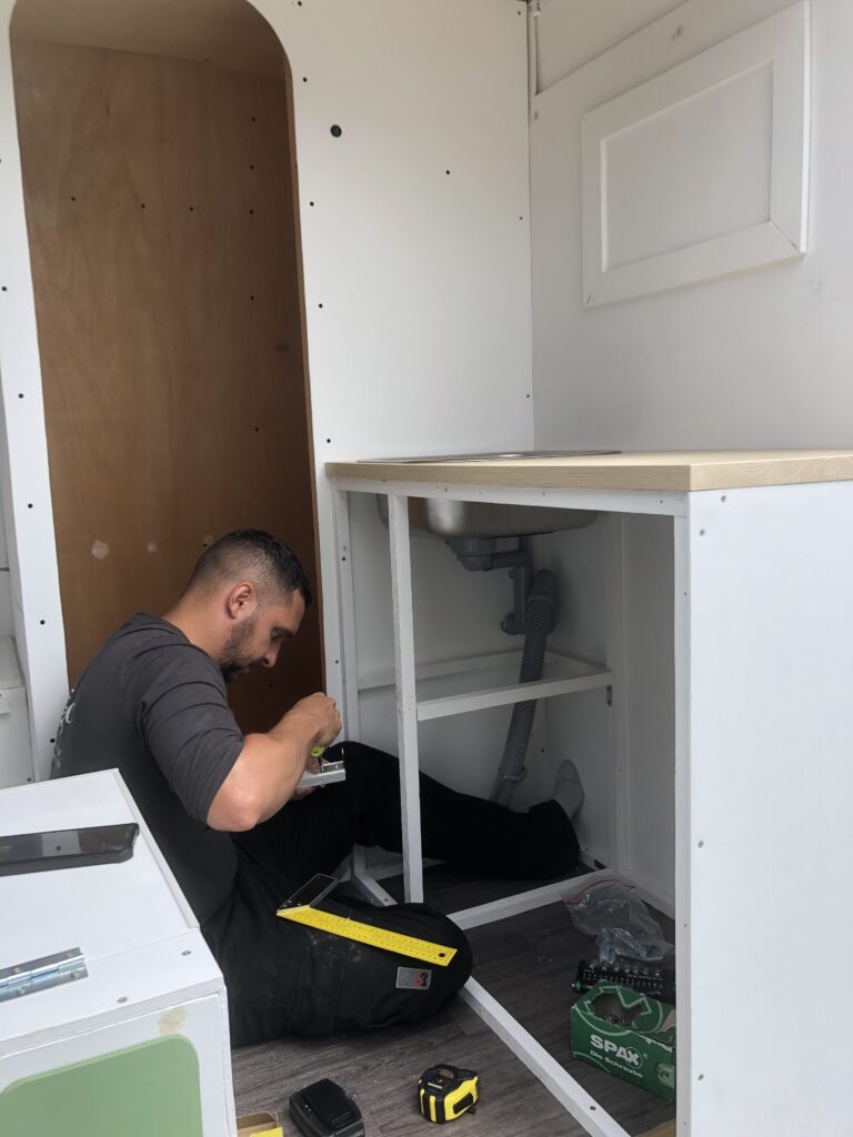 mon conjoint en train d'installer la cuisine dans notre van